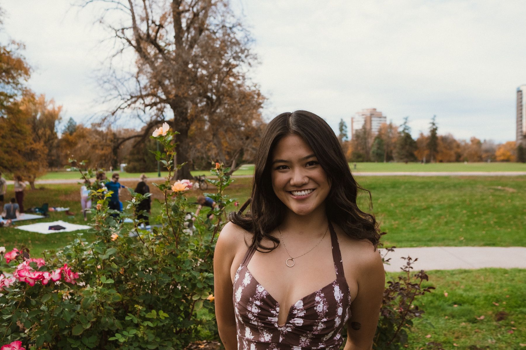 Super Pretty Girl, standig in a park with rose bushes nearby